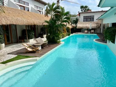 a swimming pool with chairs and a building at 1BR Tropical Villa With Pool - Canggu - Berawa in Canggu