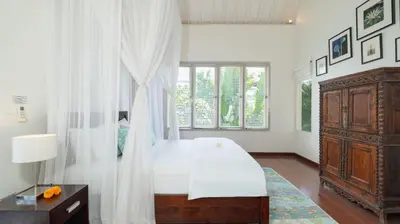 a bedroom with a bed and a dresser and a window at Villa Merta Sari 10 by Villa Finder in Seminyak
