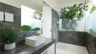 a bathroom with a sink and a mirror and plants at Villa Merta Sari 10 by Villa Finder in Seminyak