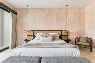 a bedroom with a large bed and a chair at Luxury Villa in Berawa Beach 3BR - Canggu in Canggu