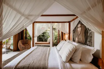 a bedroom with a large bed with a canopy at villa Pacha 2 in Seminyak