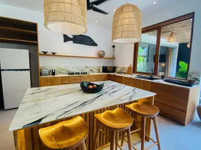 a kitchen with a large marble counter top and stools at villa Pacha 2 in Seminyak