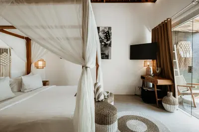a bedroom with a canopy bed and a desk at villa Pacha 2 in Seminyak