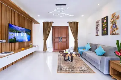 a living room with a couch and a tv at Zelene Elegant 3 BR Private Pool Villa in Seminyak