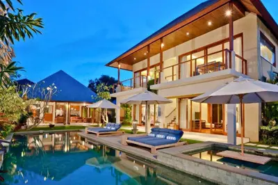 a house with a swimming pool with umbrellas at Calista Peaceful 4 BR Private Pool Villa in Canggu