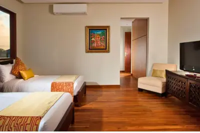 a hotel room with two beds and a flat screen tv at Calista Peaceful 4 BR Private Pool Villa in Canggu
