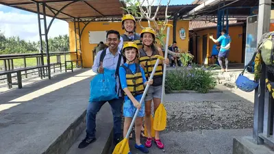 a family posing for a picture while wearing hard hats at Bali Swing with Buggy adventure and white water Rafting in Pesanggaran