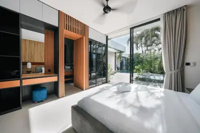a bedroom with a large bed and large windows at Villa Olivia - Umalas in Kerobokan