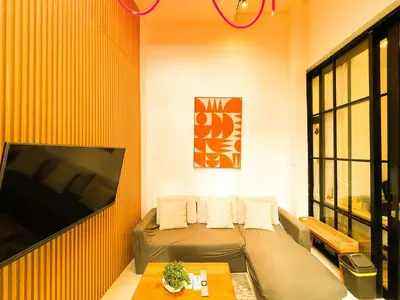 a living room with a couch and a flat screen tv at Villa Mikhail Seminyak in Seminyak