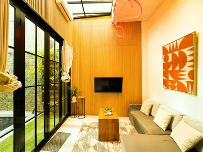 a living room with a couch and a tv at Villa Mikhail Seminyak in Seminyak