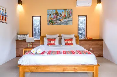 a bedroom with a large white bed with red pillows at Villa Alamanda, central location and close to restaurants in Seminyak