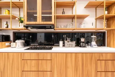 a kitchen with wooden cabinets and white counter tops at Villa Hattala - Luxury Modern Villa in Prime Berawa with Air-Conditioned Living Space in Canggu