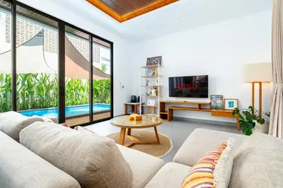 a living room with a couch and a tv at Villa Hattala - Luxury Modern Villa in Prime Berawa with Air-Conditioned Living Space in Canggu
