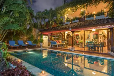 a house with a swimming pool in front of a house at Andina Spacious Garden 4 BR Private Pool Villa in Seminyak