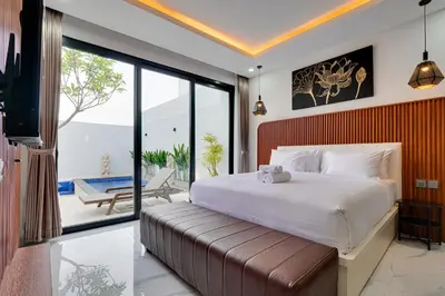 a bedroom with a large bed and a balcony at Modern 2BR Villa Reisi Malindra M12 in Denpasar in Kerobokan