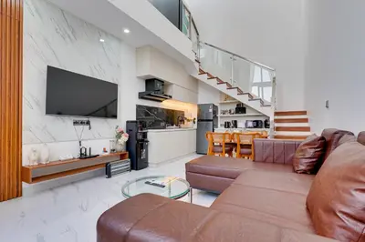 a living room with a couch and a tv and a kitchen at Modern 2BR Villa Reisi Malindra M12 in Denpasar in Kerobokan