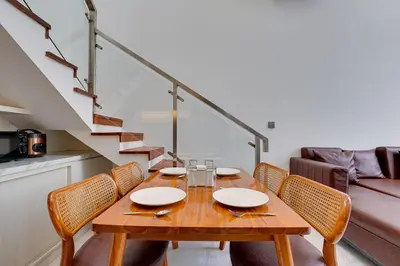 a dining room with a wooden table and chairs at Modern 2BR Villa Reisi Malindra M12 in Denpasar in Kerobokan