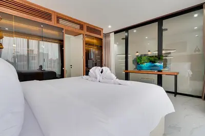 a bedroom with a white bed and a large window at Modern 2BR Villa Reisi Malindra M12 in Denpasar in Kerobokan