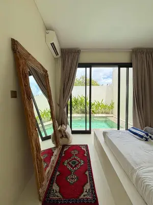 a bedroom with a bed and a view of a pool at Villa Lilla and Sauna in Canggu