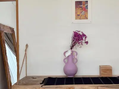 a purple vase sitting on a table with flowers in it at Villa Lilla and Sauna in Canggu