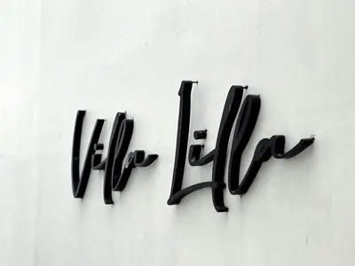 a black sign on a white wall with the word hell at Villa Lilla and Sauna in Canggu