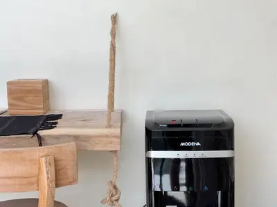 a black appliance sitting next to a wooden table at Villa Lilla and Sauna in Canggu