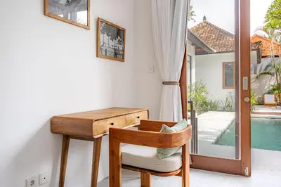 a desk and chair in a room with a pool at Ola - Private Villa - Umalas in Kerobokan