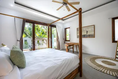 a bedroom with a large bed with a ceiling fan at Ola - Private Villa - Umalas in Kerobokan