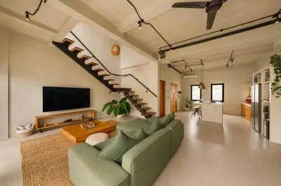 a living room with a green couch and a tv at Modern 1BR Villa with Private Pool in Kerobokan