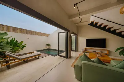 a living room with a swimming pool and a tv at Modern 1BR Villa with Private Pool in Kerobokan