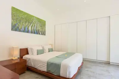a bedroom with a bed and a painting on the wall at Orvala Comfortable 2 BR Private Pool Villa in Seminyak