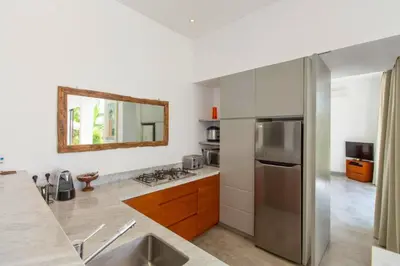 a kitchen with a stainless steel refrigerator and a mirror at Orvala Comfortable 2 BR Private Pool Villa in Seminyak