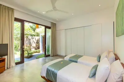a bedroom with two beds and a television in it at Orvala Comfortable 2 BR Private Pool Villa in Seminyak