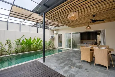 an indoor patio with a pool and a table and chairs at Springleaf Villa in Nusa Dua