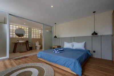 a bedroom with a bed with a blue blanket at Springleaf Villa in Nusa Dua