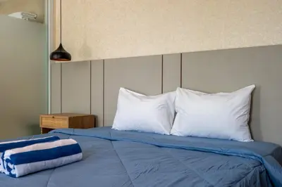 a bed with white pillows and a blue blanket at Springleaf Villa in Nusa Dua