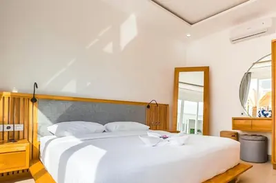 a bedroom with a large white bed and a mirror at Luxurious Semeniyak new 2BR villa with a pool in Seminyak