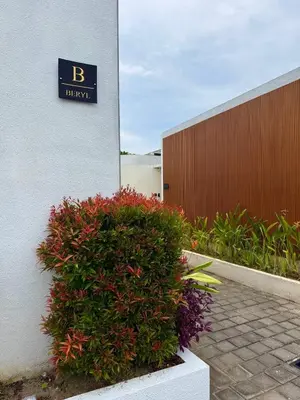 a sign on the side of a building with a bush at Luxurious Semeniyak new 2BR villa with a pool in Seminyak