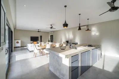 an open kitchen and living room with a table at Lotus Villa-Cozy 3BR in Canggu in Kerobokan