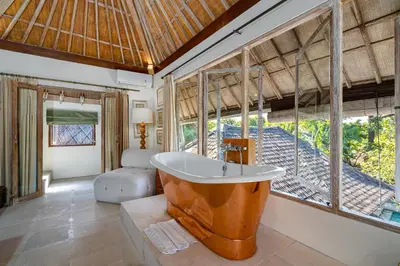 a bathroom with a large tub in a room at The Orchard house Bali by Puri Asia in Seminyak