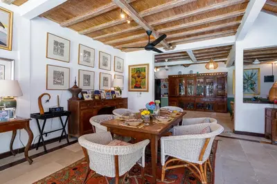 a dining room with a wooden table and chairs at The Orchard house Bali by Puri Asia in Seminyak
