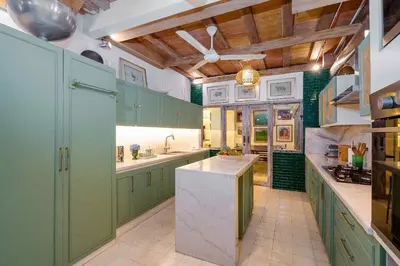 a large kitchen with green cabinets and a ceiling at The Orchard house Bali by Puri Asia in Seminyak