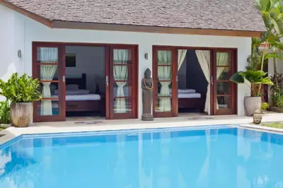 a swimming pool in front of a villa at Philana Cozy 3 BR Private Pool Villa in Seminyak