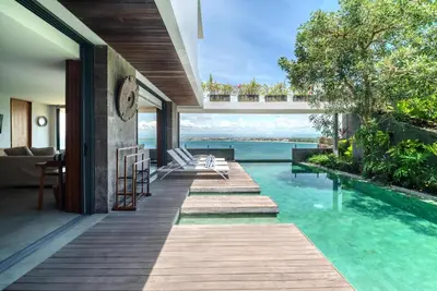 a house with a swimming pool with a view of the ocean at Santos Cliff View Jimbaran in Jimbaran