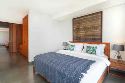 a bedroom with a large bed with a wooden headboard at Santos Cliff View Jimbaran in Jimbaran