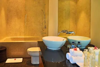 a bathroom with two sinks and a toilet and a tub at Fidela Comfortable 3 BR Private Pool Villa in Seminyak