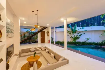 a living room with a couch and a swimming pool at Fidela Comfortable 3 BR Private Pool Villa in Seminyak