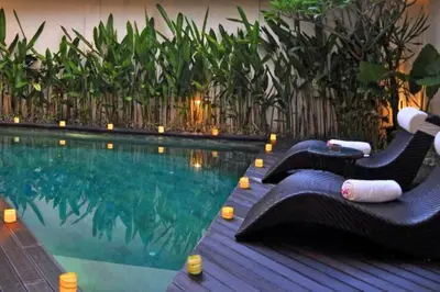 a swimming pool with lounge chairs next to the water at Fidela Comfortable 3 BR Private Pool Villa in Seminyak