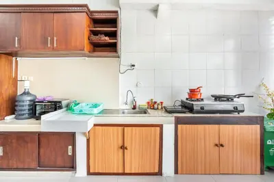 a kitchen with wooden cabinets and a sink at Cening Villa Seminyak in Seminyak