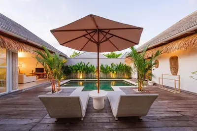 a patio with an umbrella and a swimming pool at Tropical 2BR Pool Villa near Seminyak & Canggu in Kerobokan